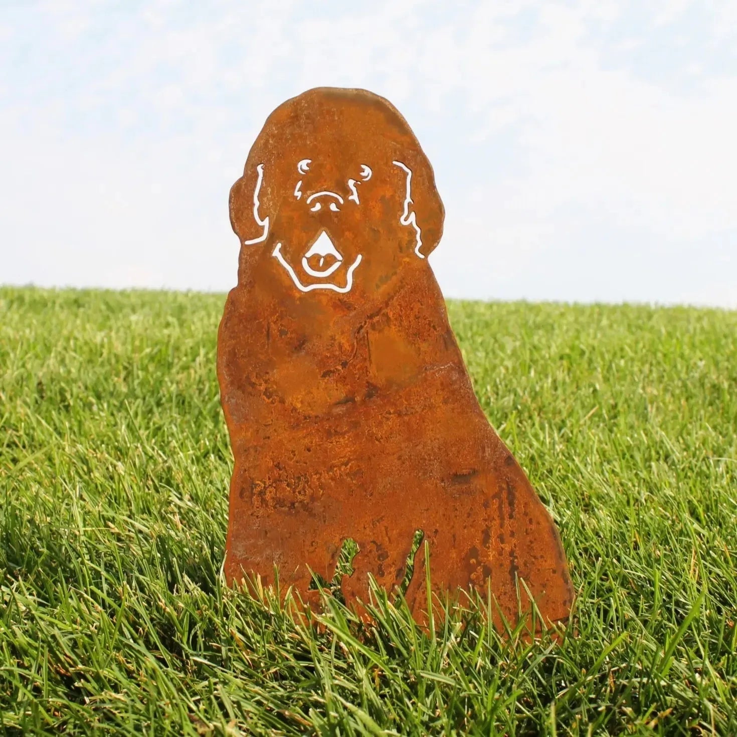 Corten steel Newfoundland dog silhouette with rust patina on grass, adding rustic charm to outdoor decor.