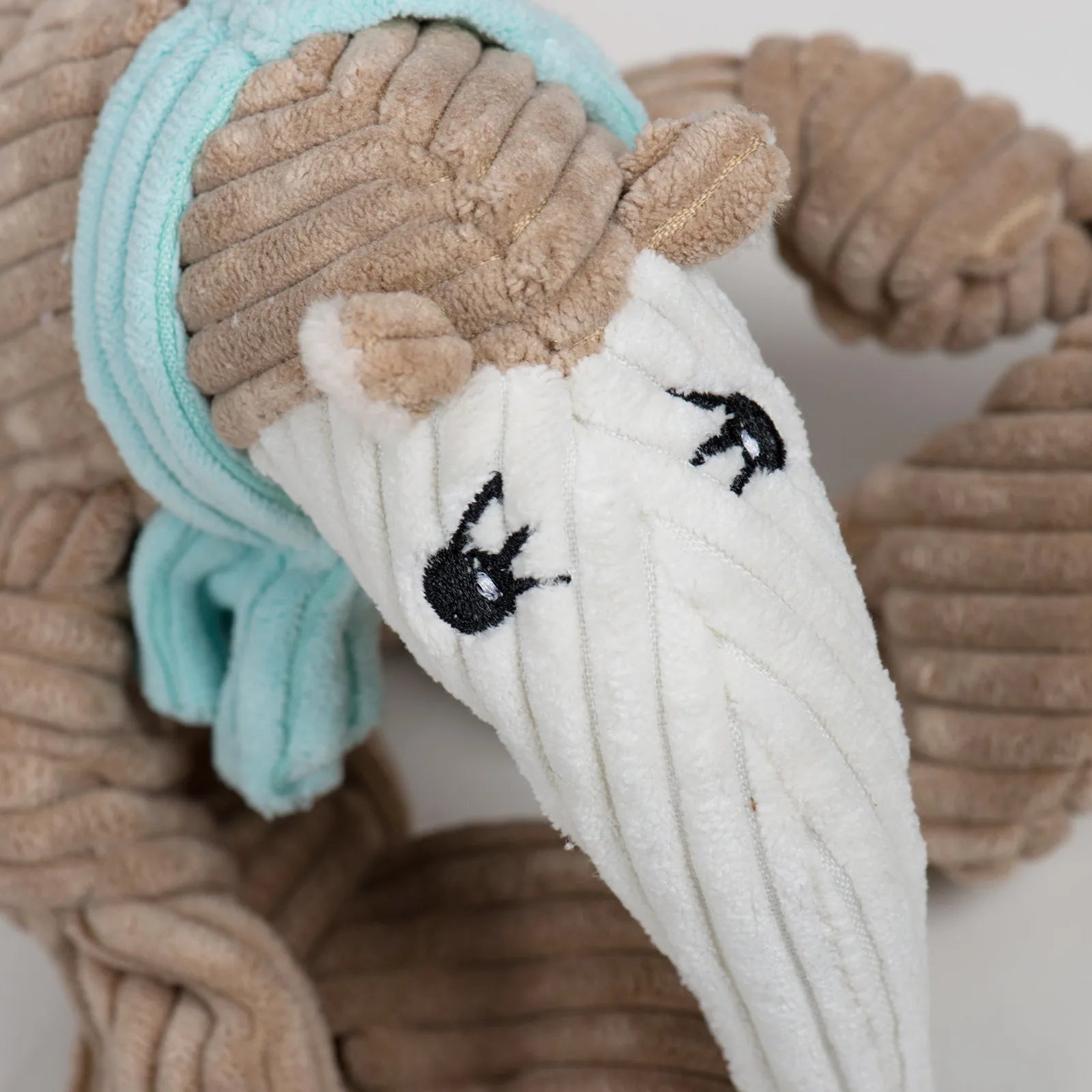Plush Nibblet Anteater Knottie® dog toy in tan and white, featuring a long nose, knotted limbs, and embroidered eyes.