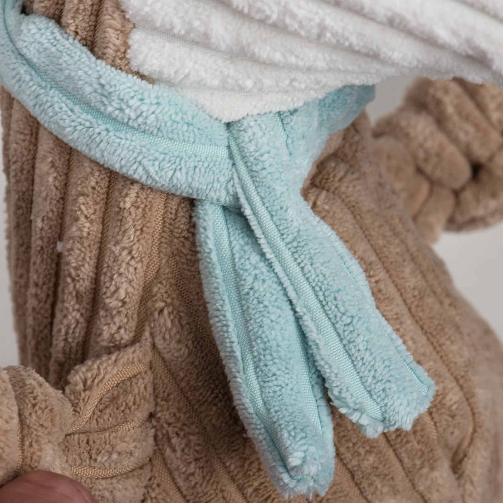 Soft plush Nibblet Anteater Knottie® toy featuring a light blue bow and tan textured body, perfect for interactive play.