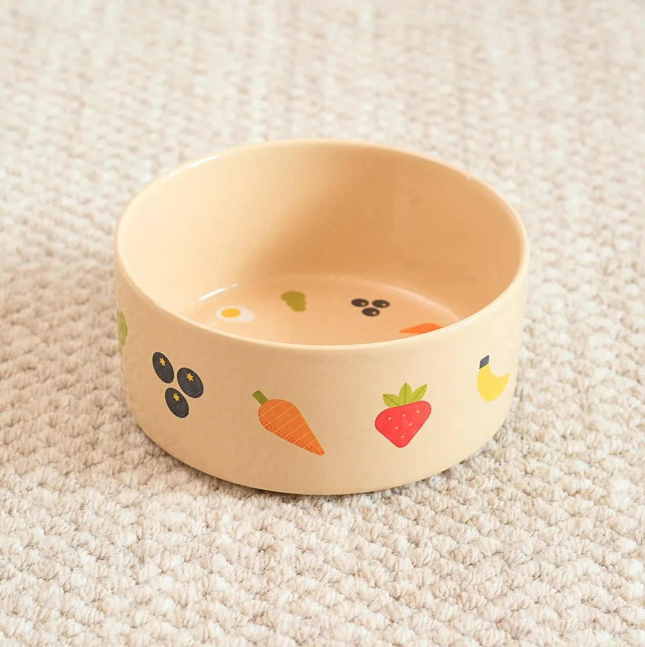 Beige pet bowl with colorful fruit and vegetable illustrations, made from food-grade ceramic, designed for safe feeding.