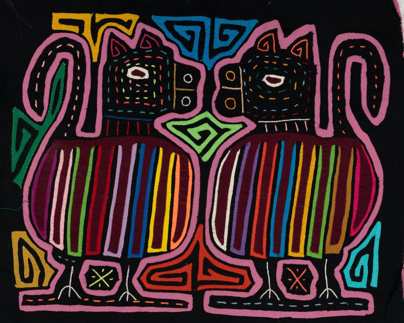 Hand-stitched Mola featuring two stylized dogs with colorful stripes on a black background, showcasing traditional Panaman...