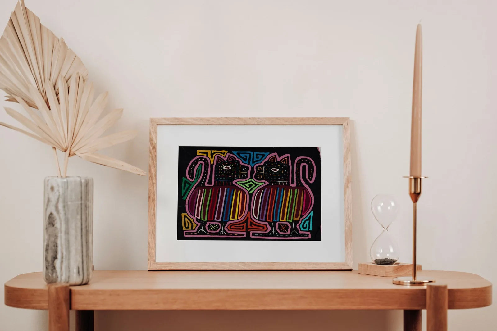Hand-stitched Mola tapestry featuring two colorful dog designs with geometric patterns on a black background.
