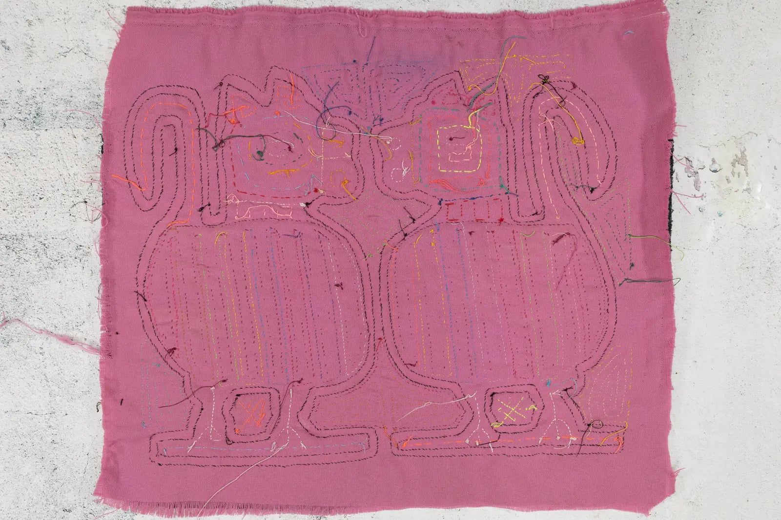 Hand-stitched pink Mola features two playful puppy dog outlines with colorful stitching details.