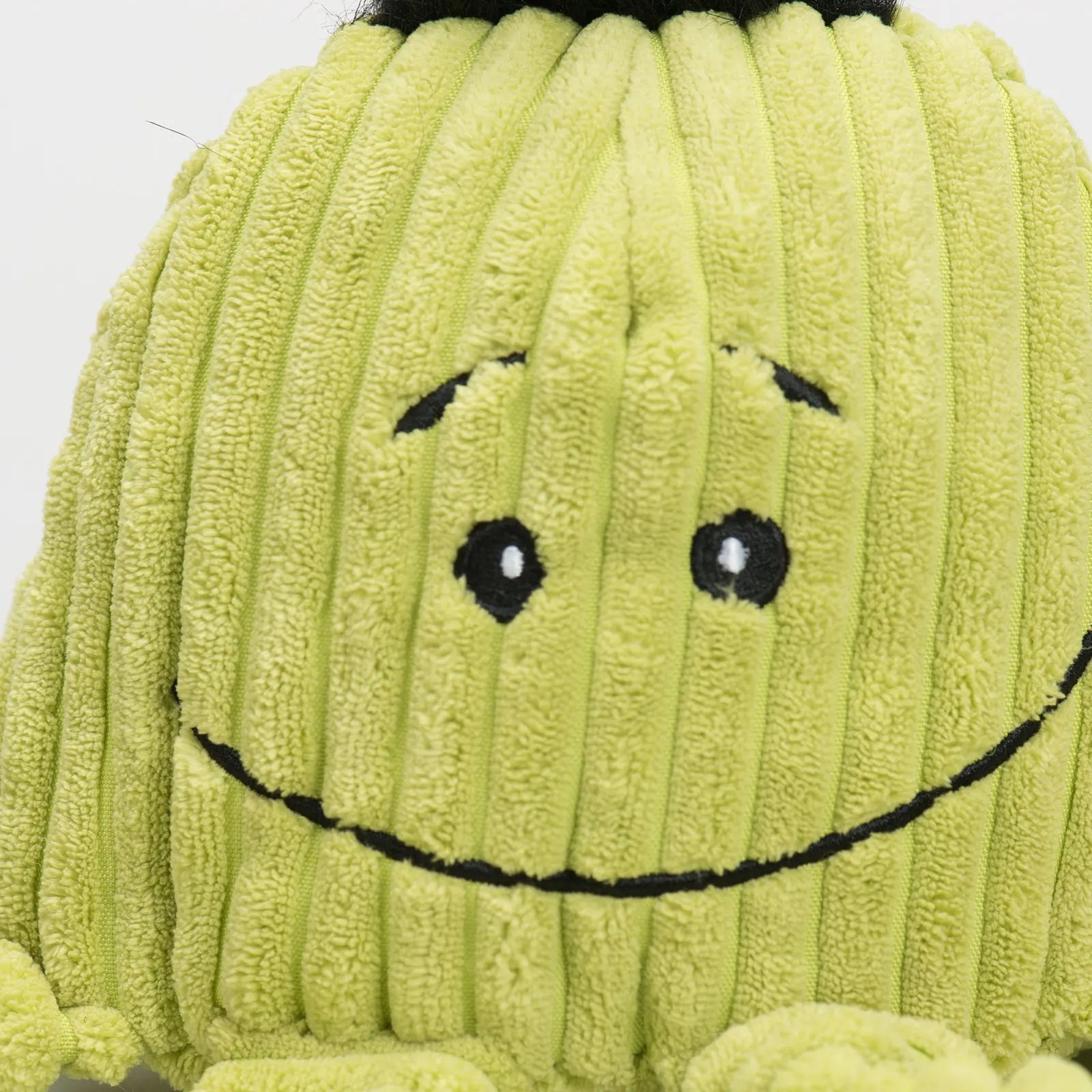 Smiling green plush octopus dog toy with ribbed texture, perfect for interactive play and cuddling.