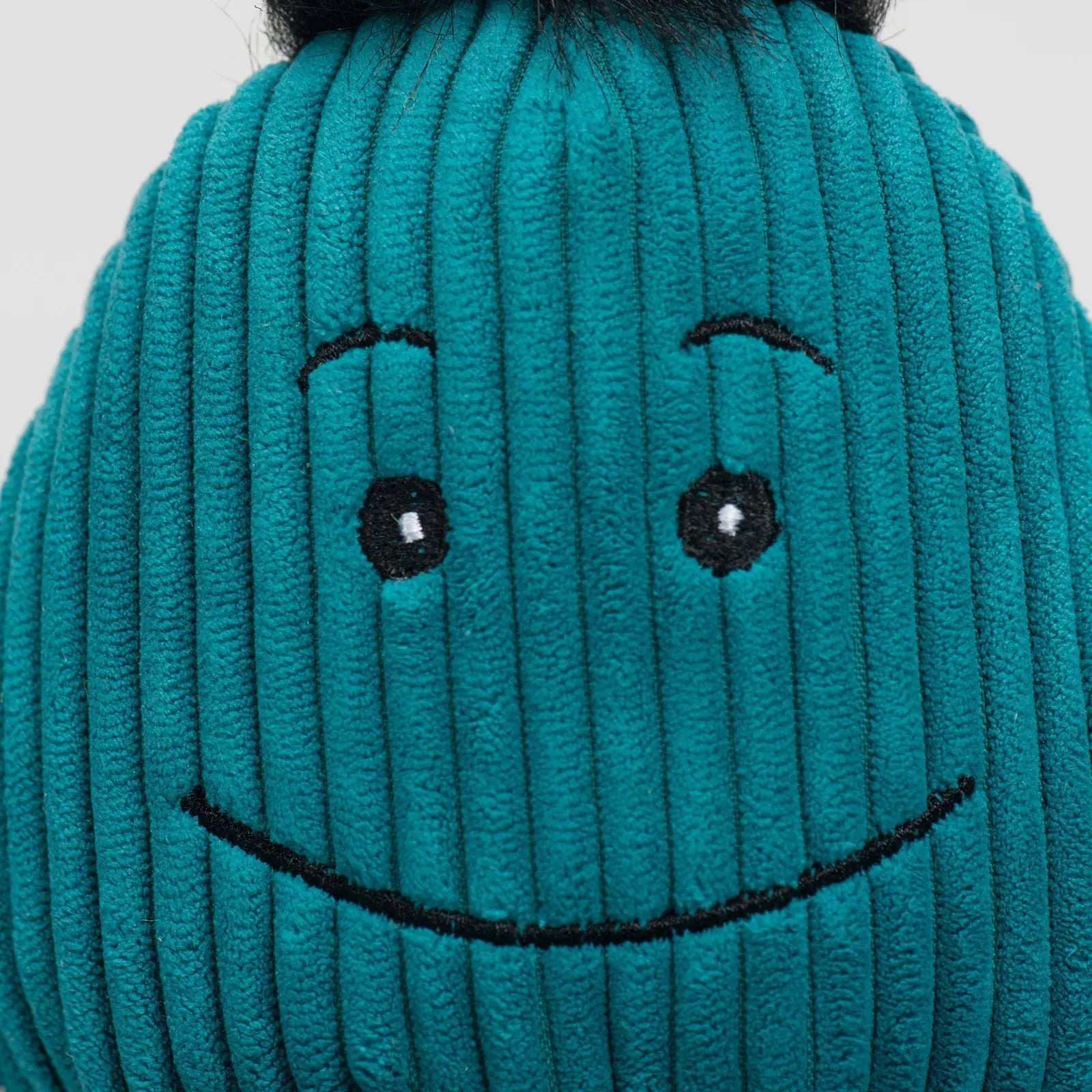 Teal plush octopus toy with a smiling face, ribbed texture, and black fur accents, designed for dog play and cuddling.