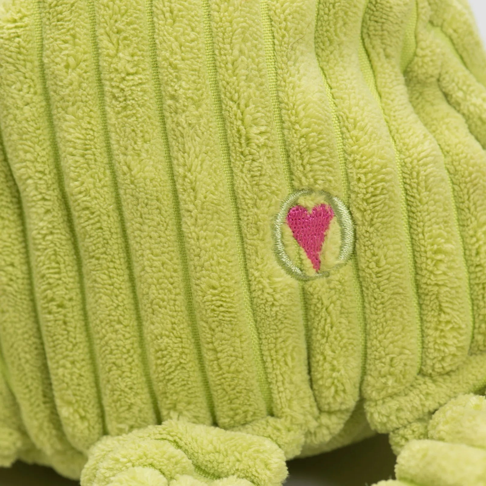 Bright green plush octopus toy with textured stripes and a pink heart patch, ideal for dog play and cuddling.