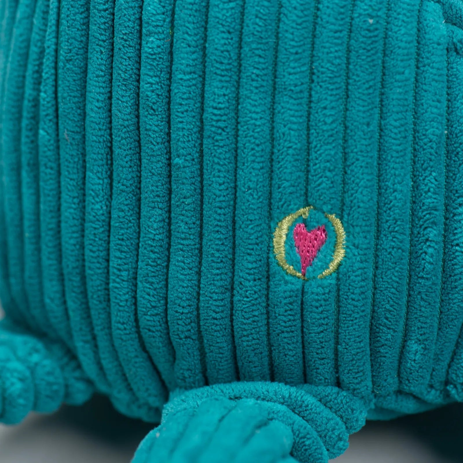 Teal plush Octavie Octopus toy with ribbed texture and embroidered heart logo, designed for dogs to tug and cuddle.