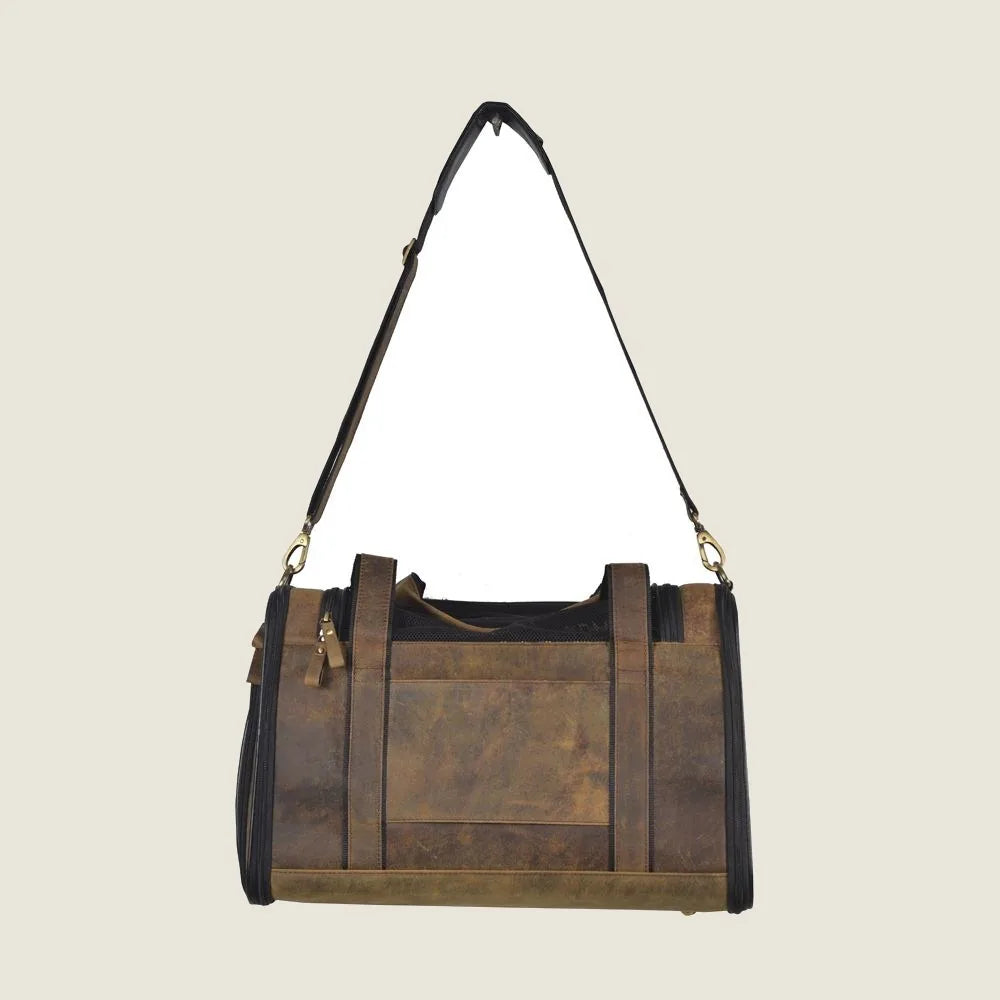 Stylish dark brown leather dog bag with adjustable shoulder strap and sturdy handles for carrying small to medium pets.
