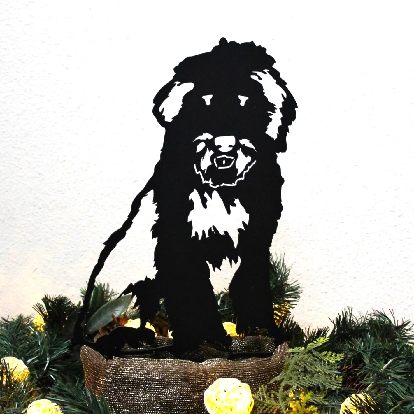 Black metal silhouette of an Old English Sheepdog, showcasing intricate details, displayed with holiday decor.