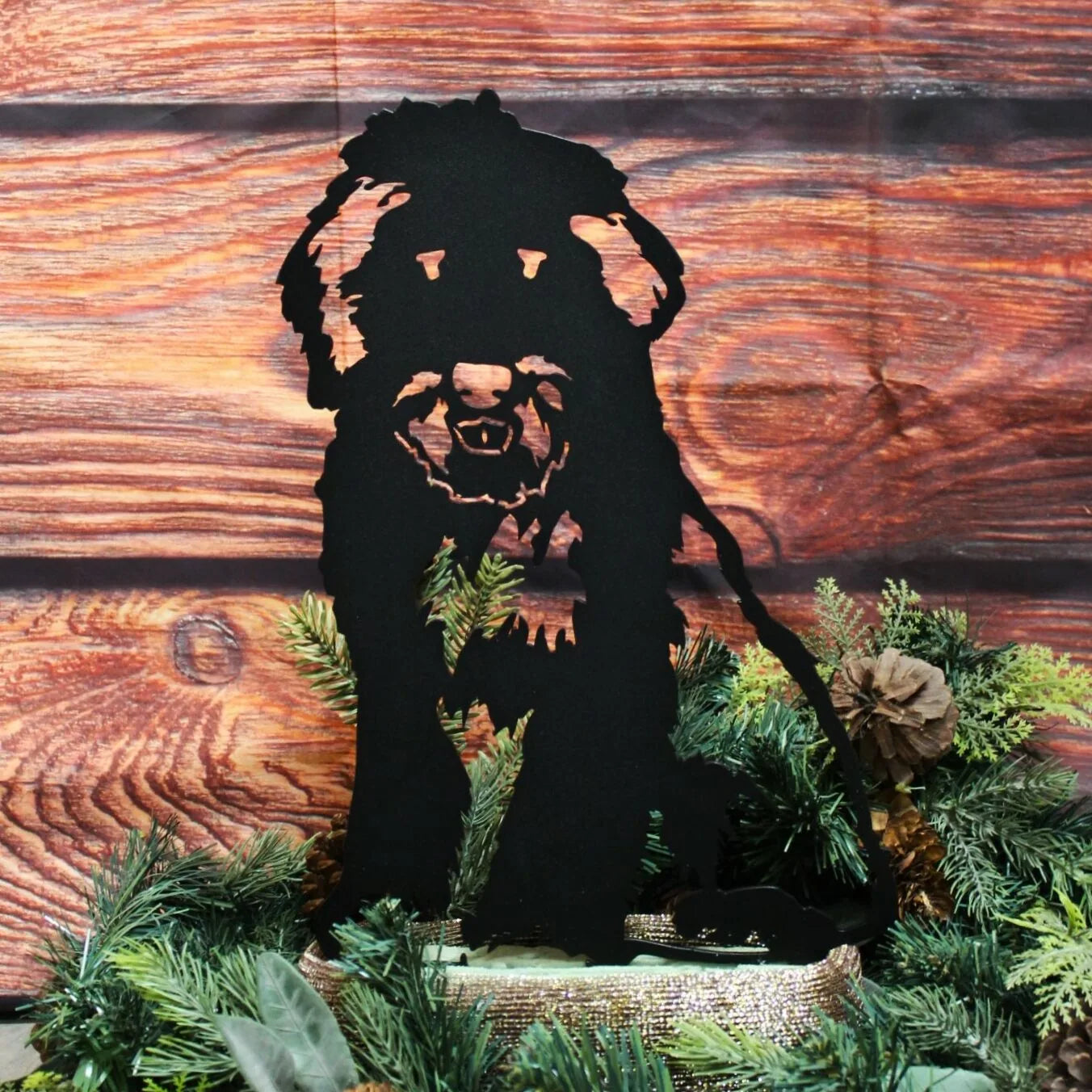 Old English Sheepdog silhouette in matte black metal, surrounded by greenery against a rustic wooden backdrop.