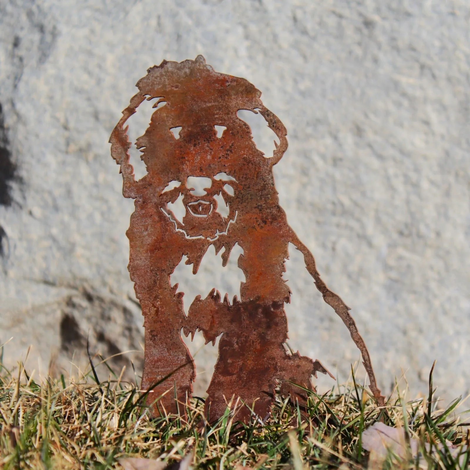 Rusty metal silhouette of an Old English Sheepdog on grass, showcasing intricate detailing in Corten steel.