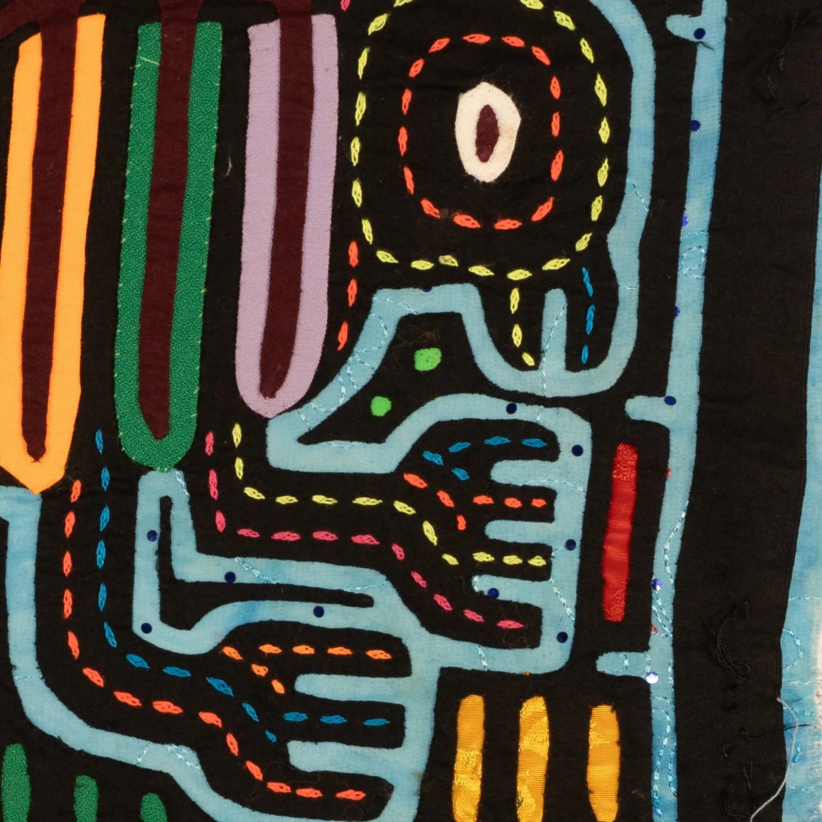 Colorful hand-stitched Mola design featuring abstract shapes and patterns, showcasing vibrant threads on a blue background.