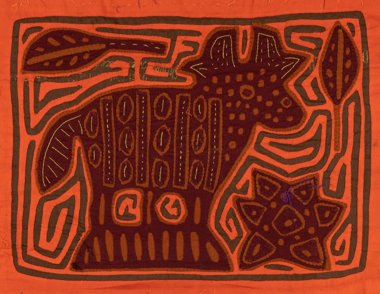 Hand-stitched orange and brown puppy design on a vibrant tapestry, featuring intricate patterns and textures.