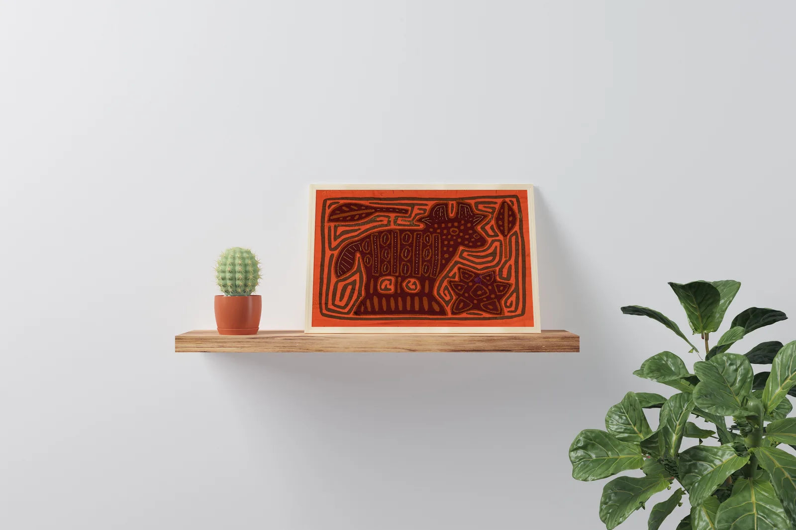 Hand-stitched orange and brown Mola tapestry of a puppy, displayed on a wooden shelf beside a potted cactus.