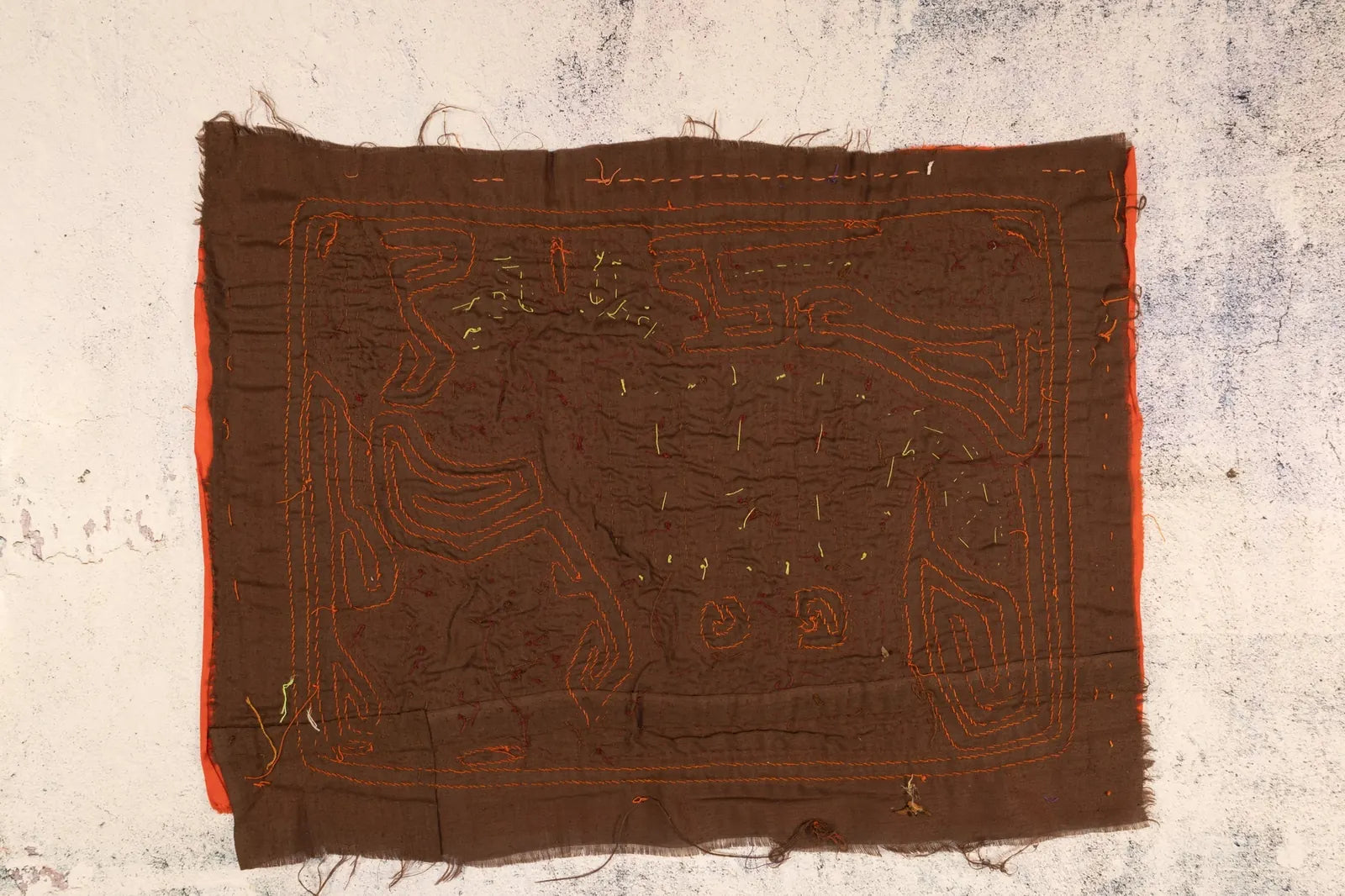 Hand-stitched brown tapestry with orange geometric patterns, depicting a puppy in a jungle scene.