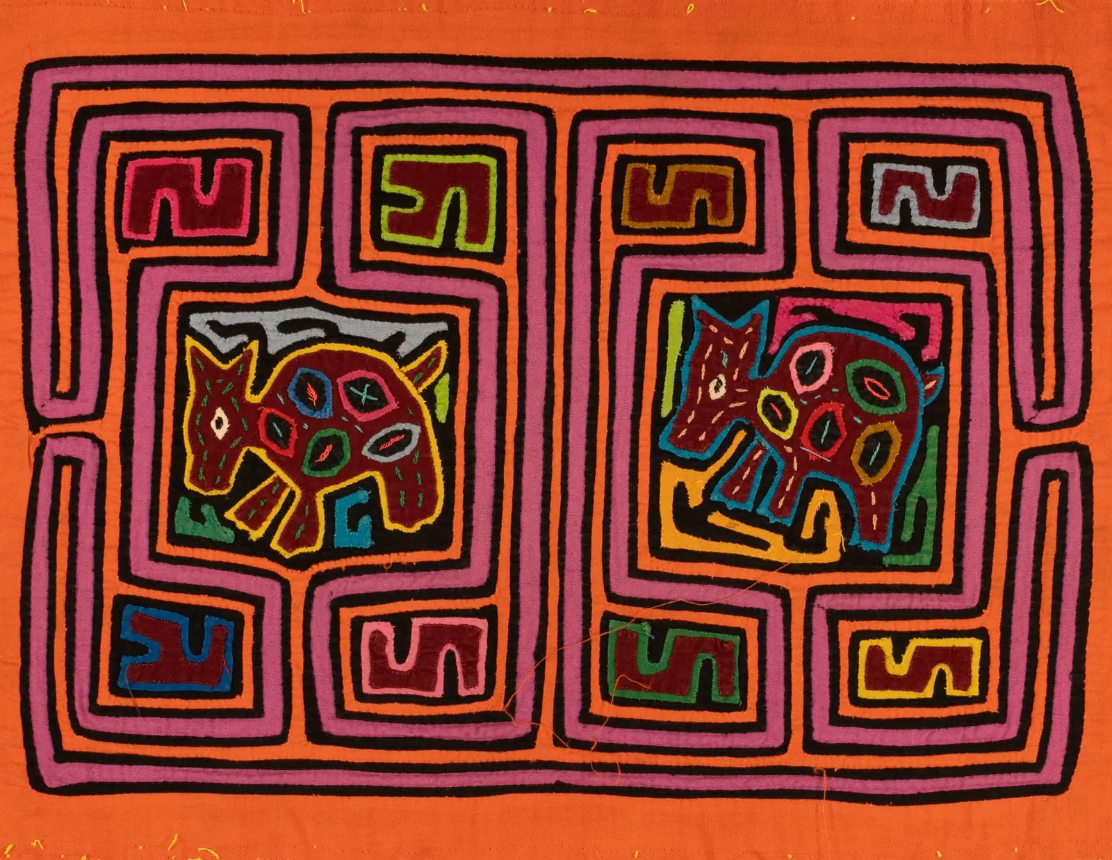 Bright orange Mola featuring playful puppy designs in purple, pink, green, and black, crafted from hand-stitched textile.