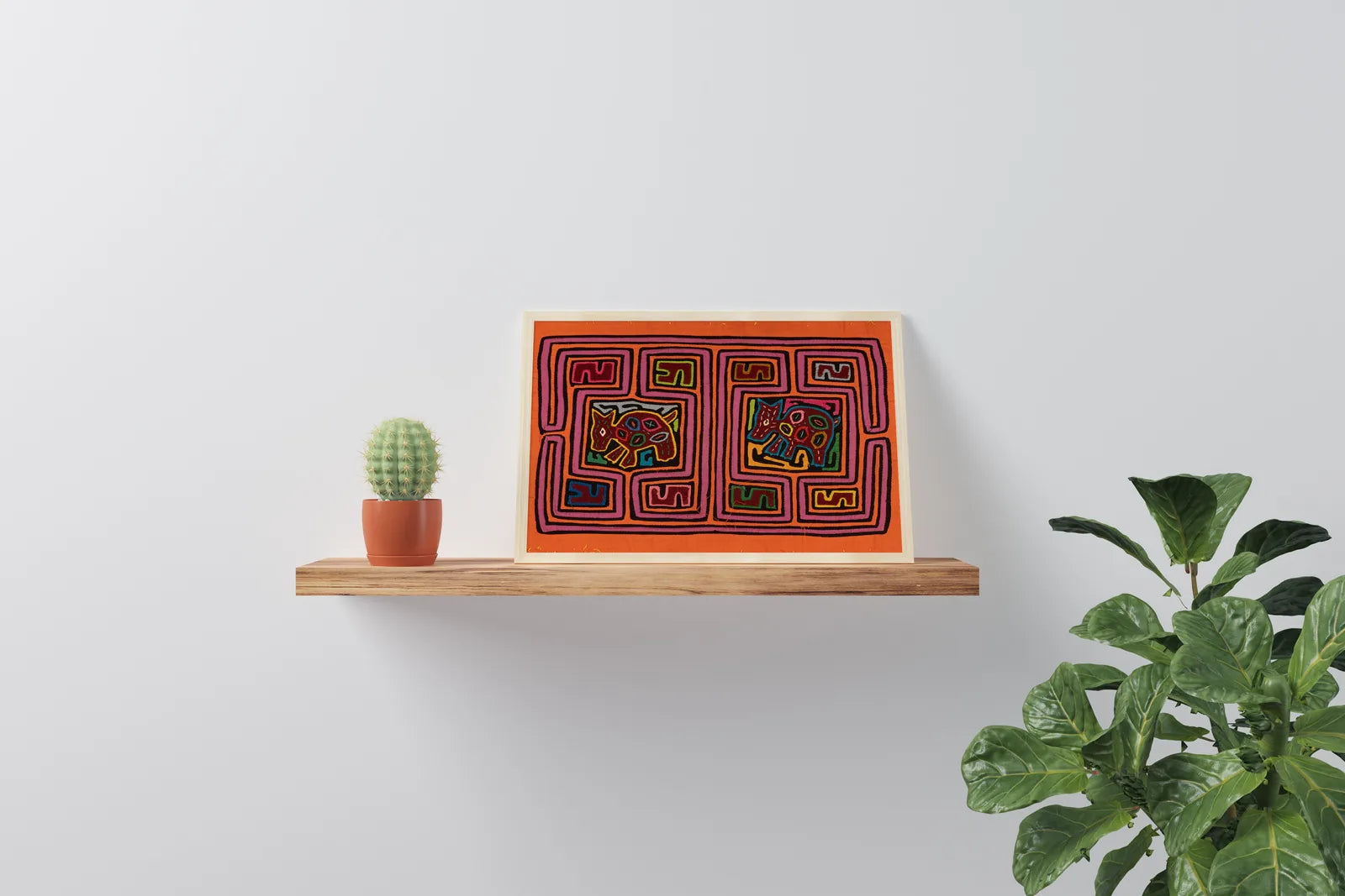 Hand-stitched orange and purple dog Mola on a shelf, surrounded by a cactus and leafy plant.