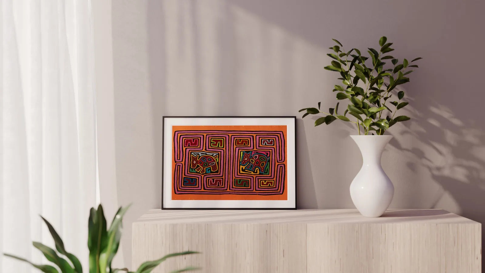 Colorful hand-stitched orange and purple Mola tapestry featuring geometric dog designs, framed and displayed on a wooden s...