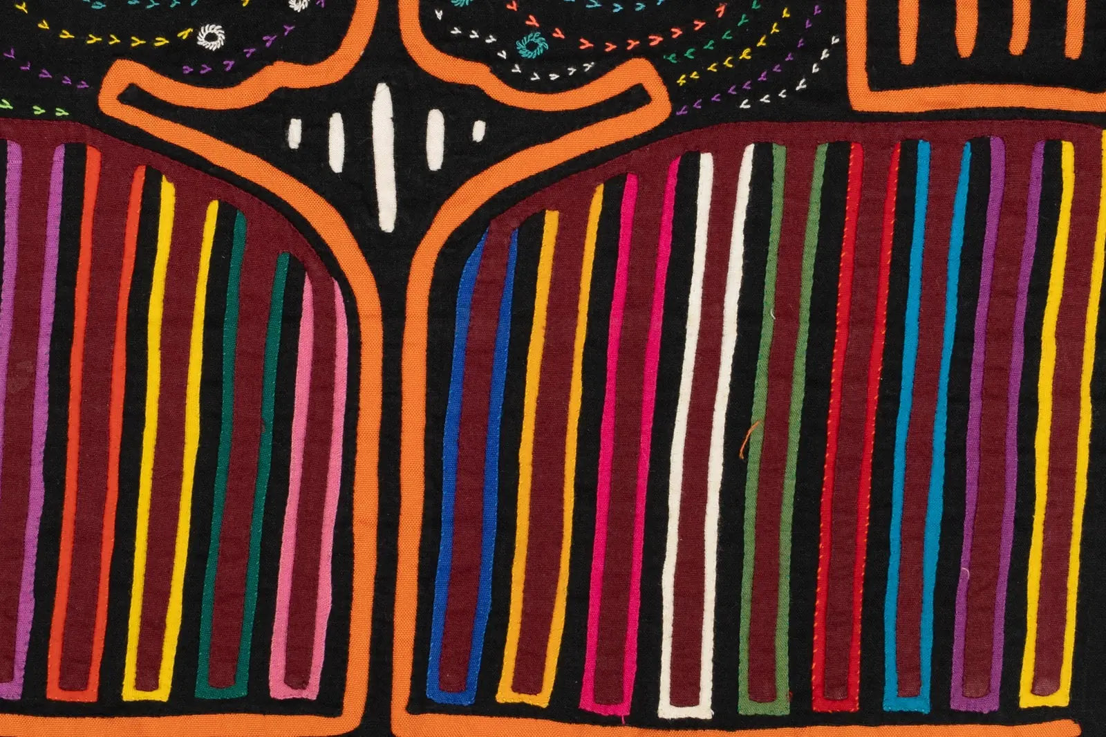 Vibrant orange, black, and multicolored hand-stitched textile showcasing abstract patterns, representing Panama's indigeno...