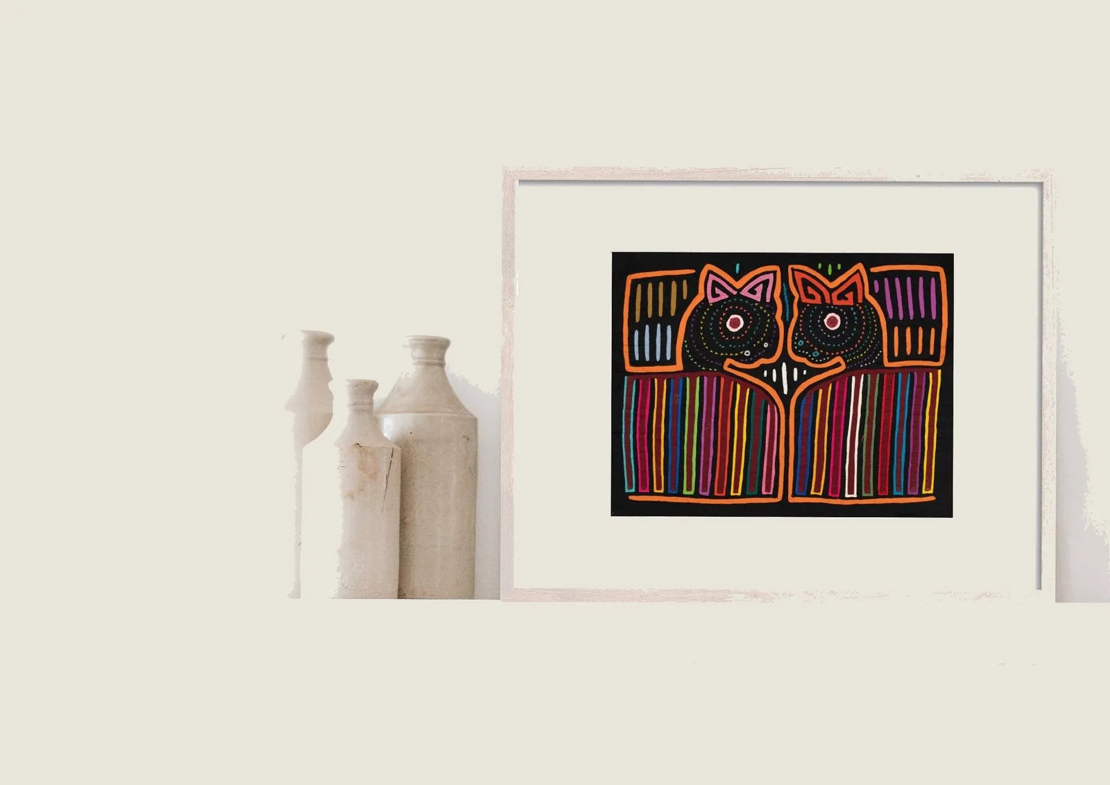 Colorful hand-stitched Mola featuring two abstract puppy faces with geometric patterns on a black background.