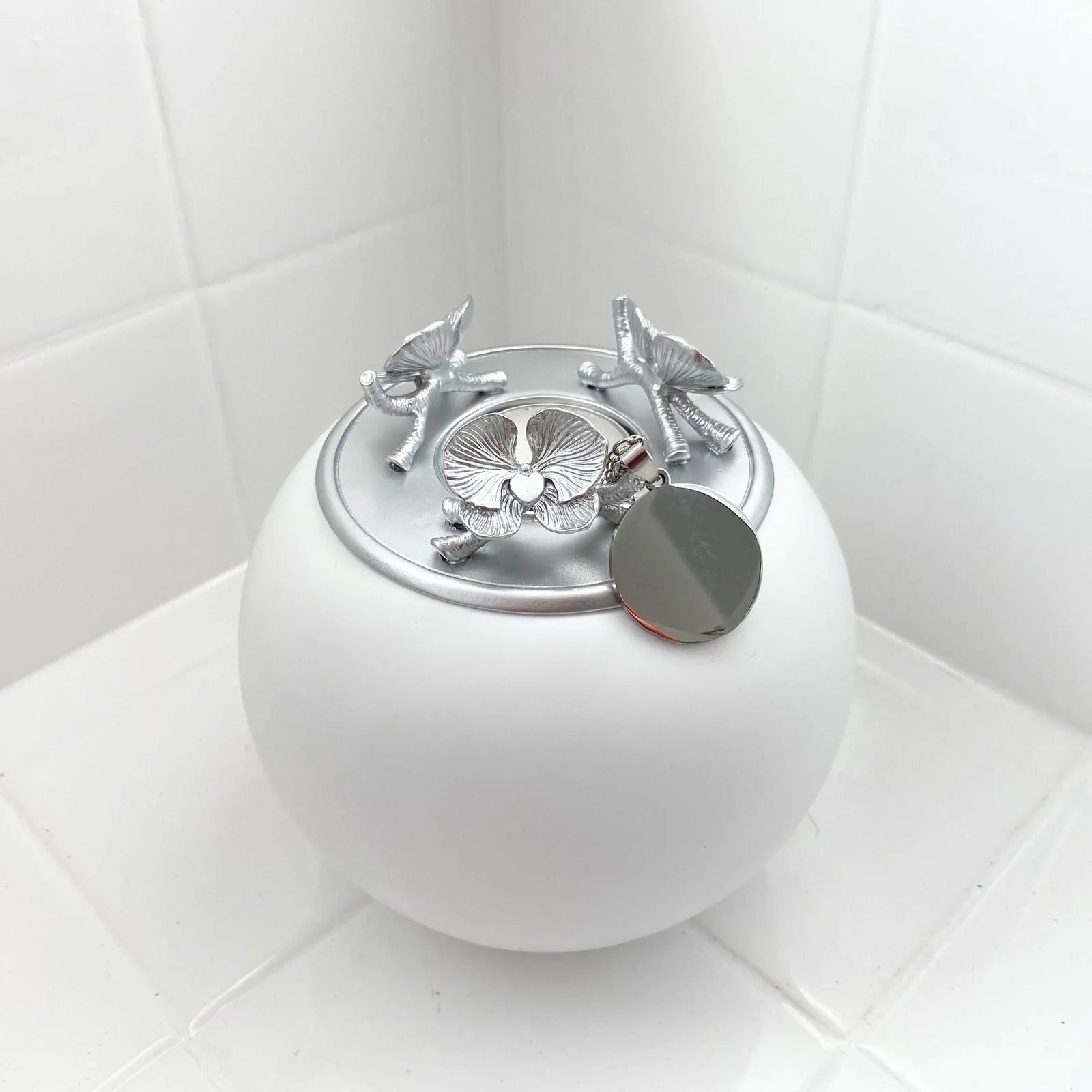 Handmade white orchid urn with silver floral lid and engraved tag, designed for pet memorials.