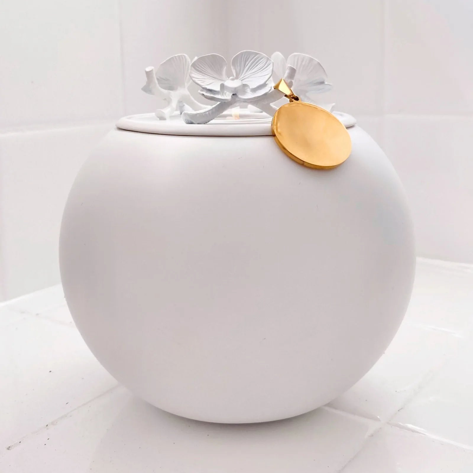 Handmade white orchid urn for dog ashes, featuring a floral design and a gold pendant tag for personalization.