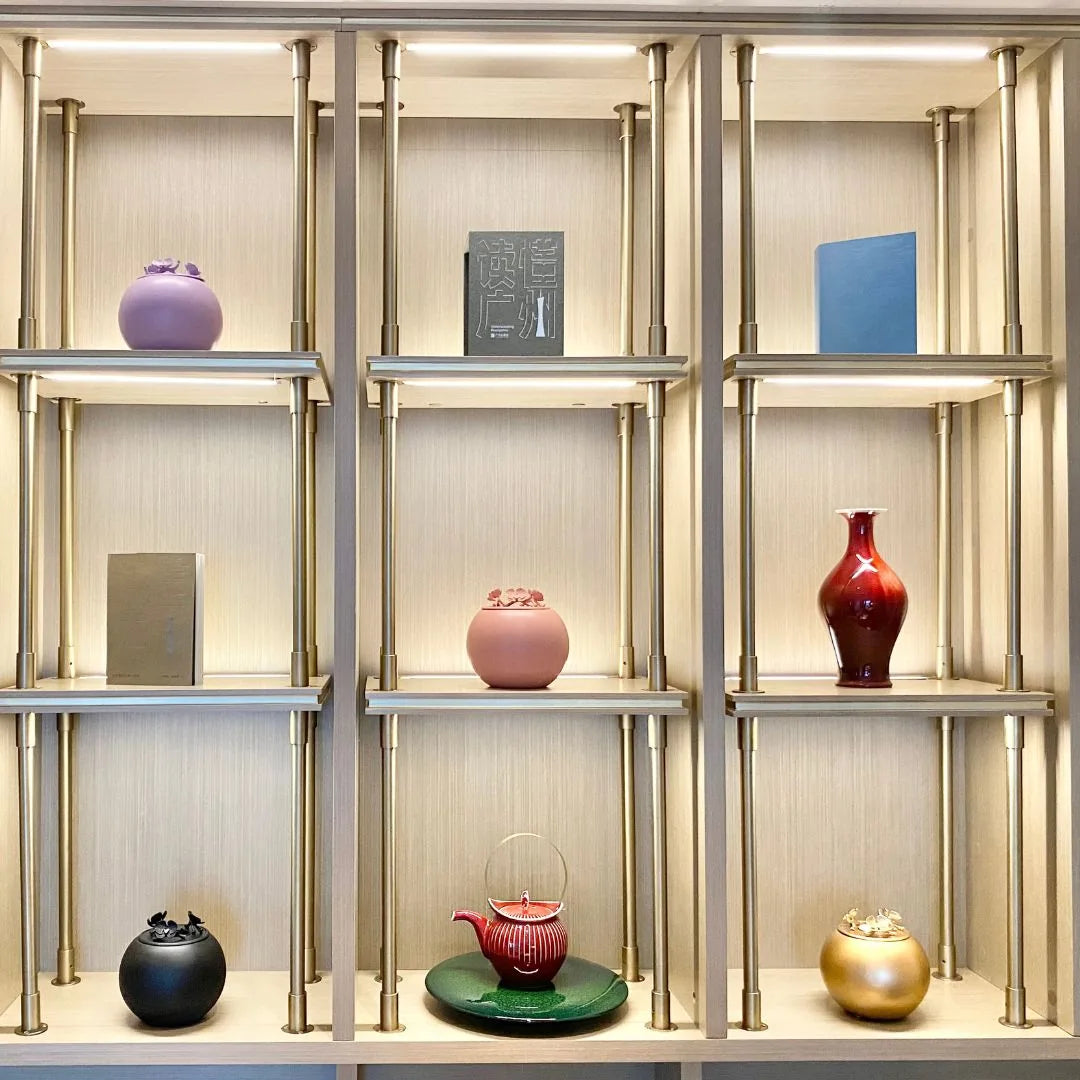 Handmade coral Orchid Urn for dog ashes, elegantly displayed among decorative pieces on a modern shelf.