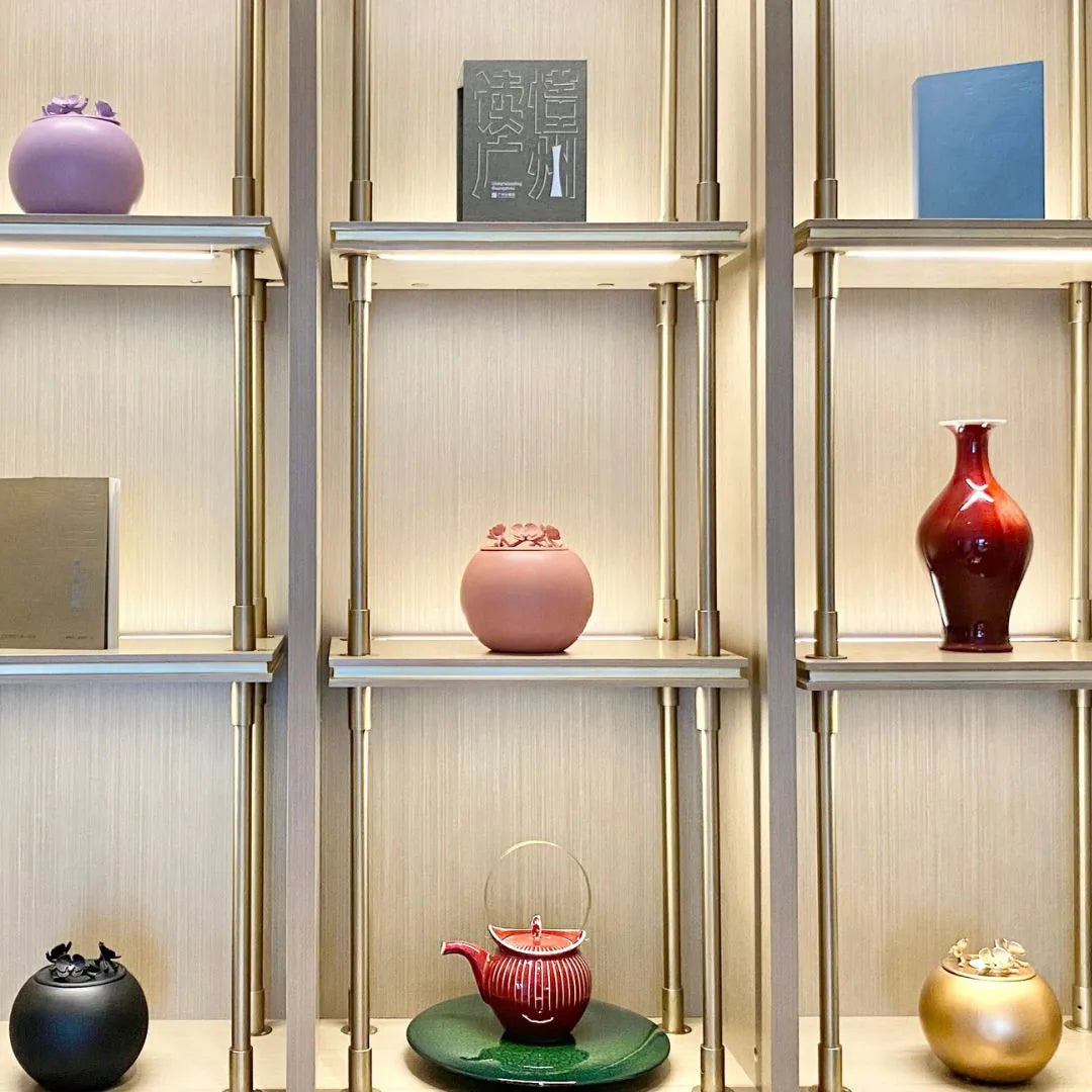 Elegant gold Orchid Urn for dog ashes displayed on a stylish shelf, surrounded by other decorative items.