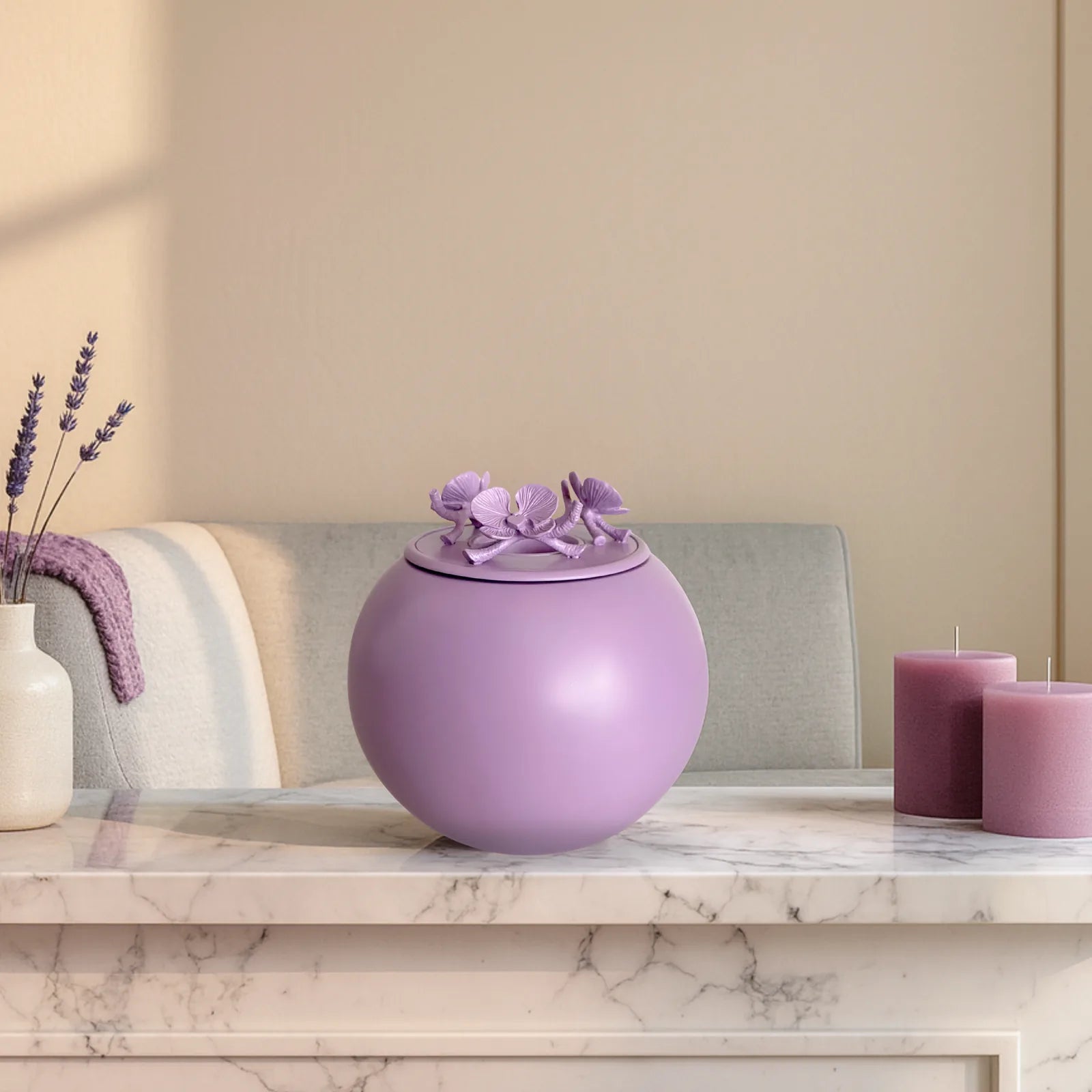 Handmade lavender orchid urn for pet ashes, featuring a floral lid, displayed on a marble countertop with candles.