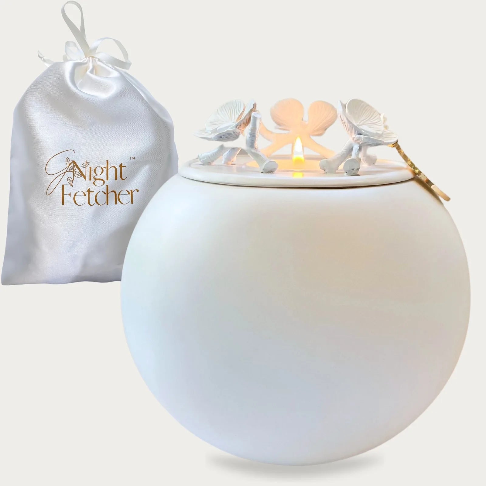 Handmade white ceramic keepsake urn with elegant floral details and a matching silk pouch for memorial use.