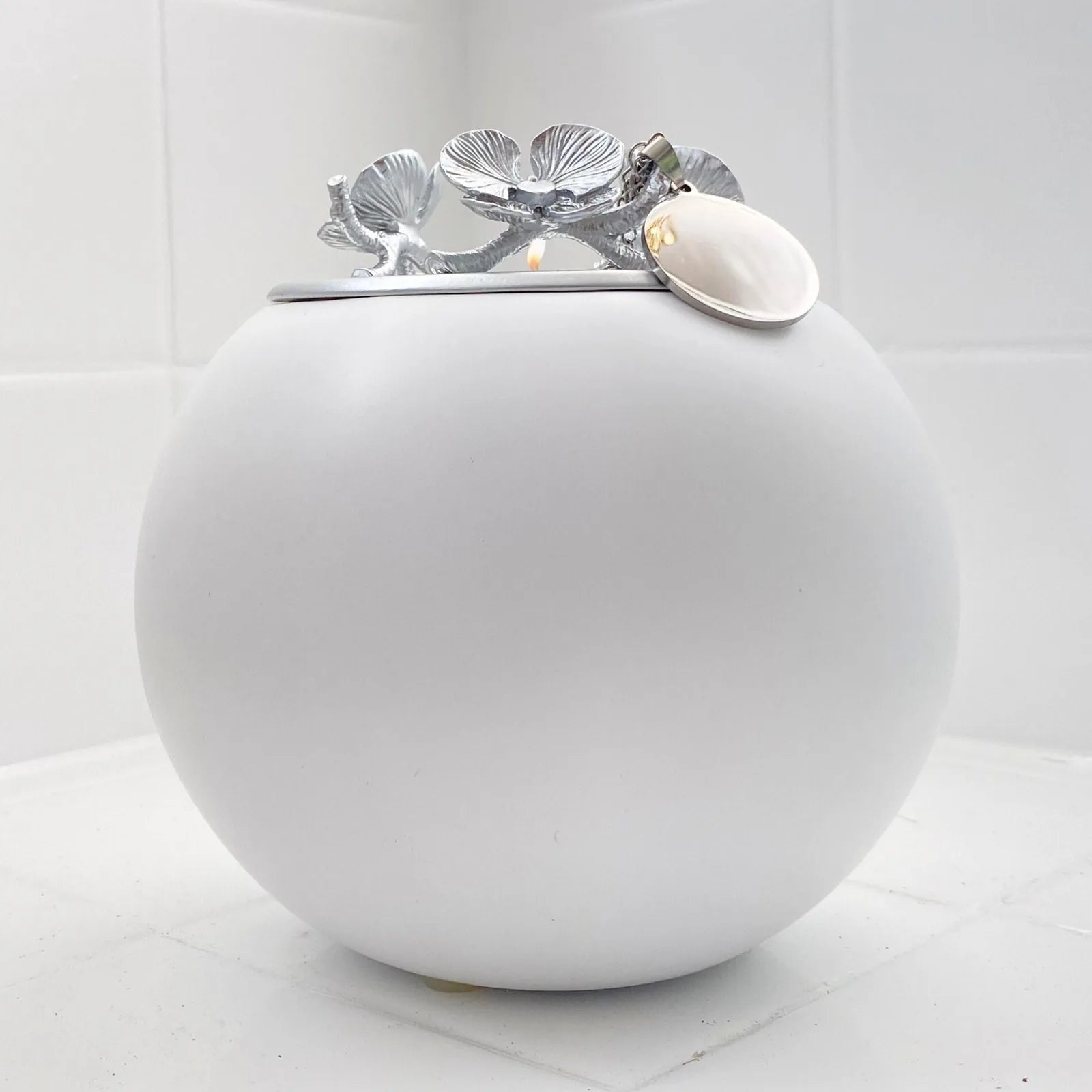Elegant white orchid urn for pets, featuring a stainless steel lid with an intricate floral design.