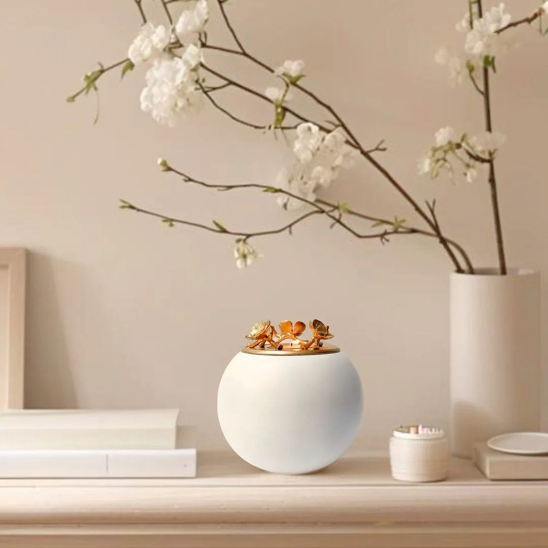 Handmade white floral-patterned orchid urn from GNight Fetcher, elegantly displayed on a light wood shelf with decor.