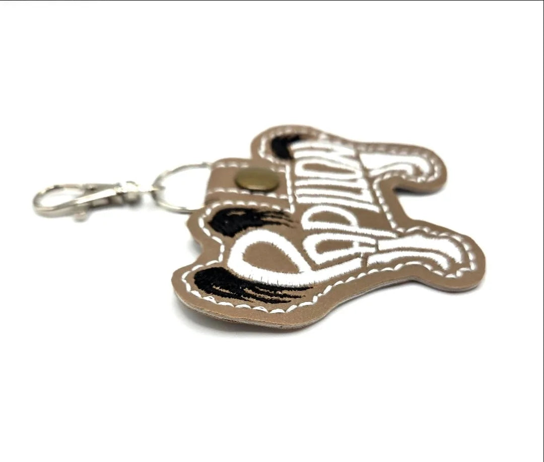 Tan Papillon dog silhouette keychain with black embroidery and silver-tone clasp, perfect for dog lovers.