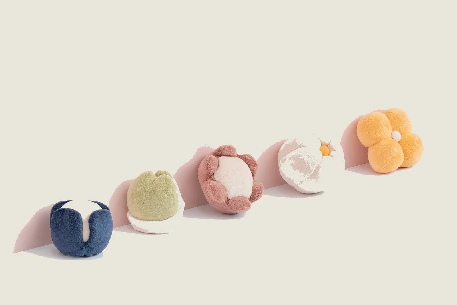 Colorful plush dog toys in various flower shapes, featuring soft textures and a built-in squeaker for playtime fun.
