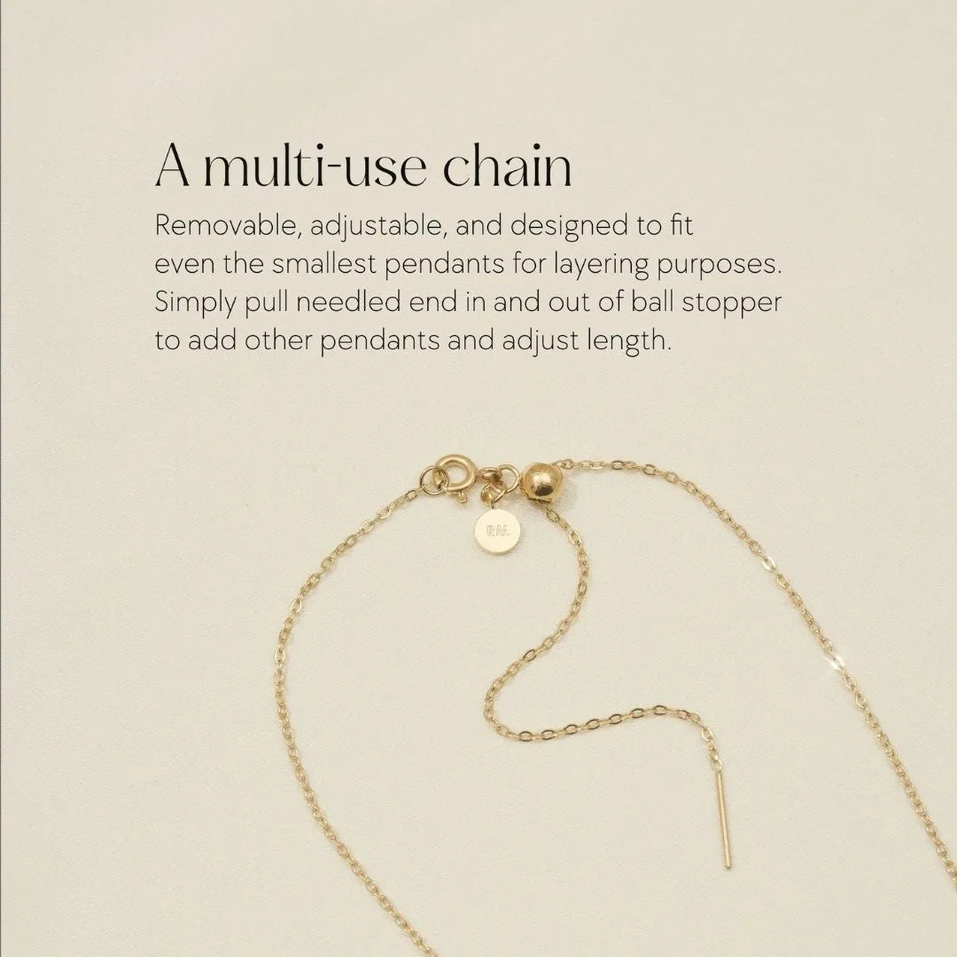 Gold adjustable chain designed for layering, featuring a ball stopper and a small tag, perfect for pendants.