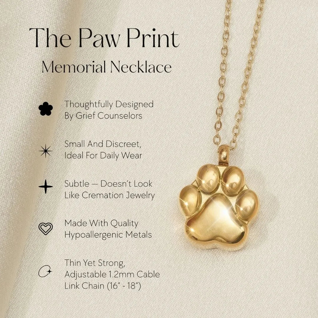 Gold paw print cremation necklace on a delicate chain, designed as a subtle memorial for pet ashes.