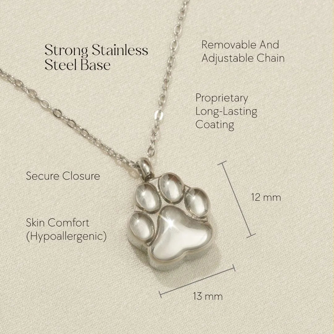 Silver paw print cremation necklace with adjustable chain, designed to hold pet ashes or keepsakes.