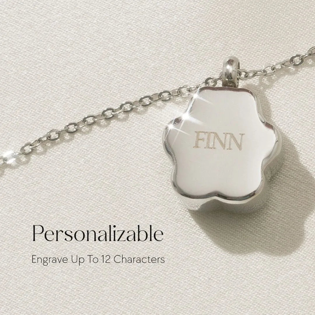 Silver paw print cremation necklace with "FINN" engraving, designed for pet memorial jewelry and personal keepsakes.