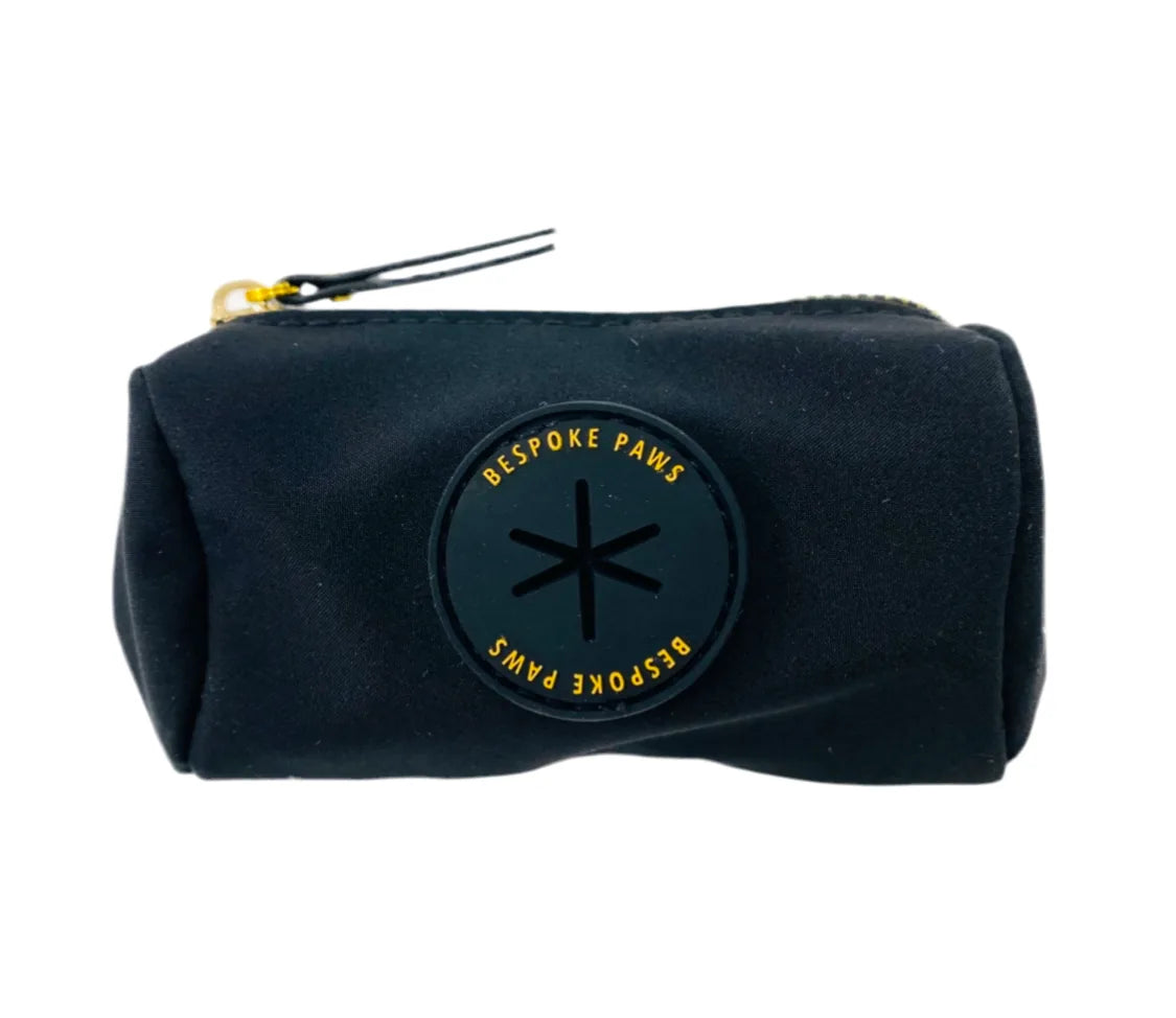Sleek black waste bag dispenser with a rubber BESPOKE PAWS logo, featuring a dangle-free design for stylish dog walks.