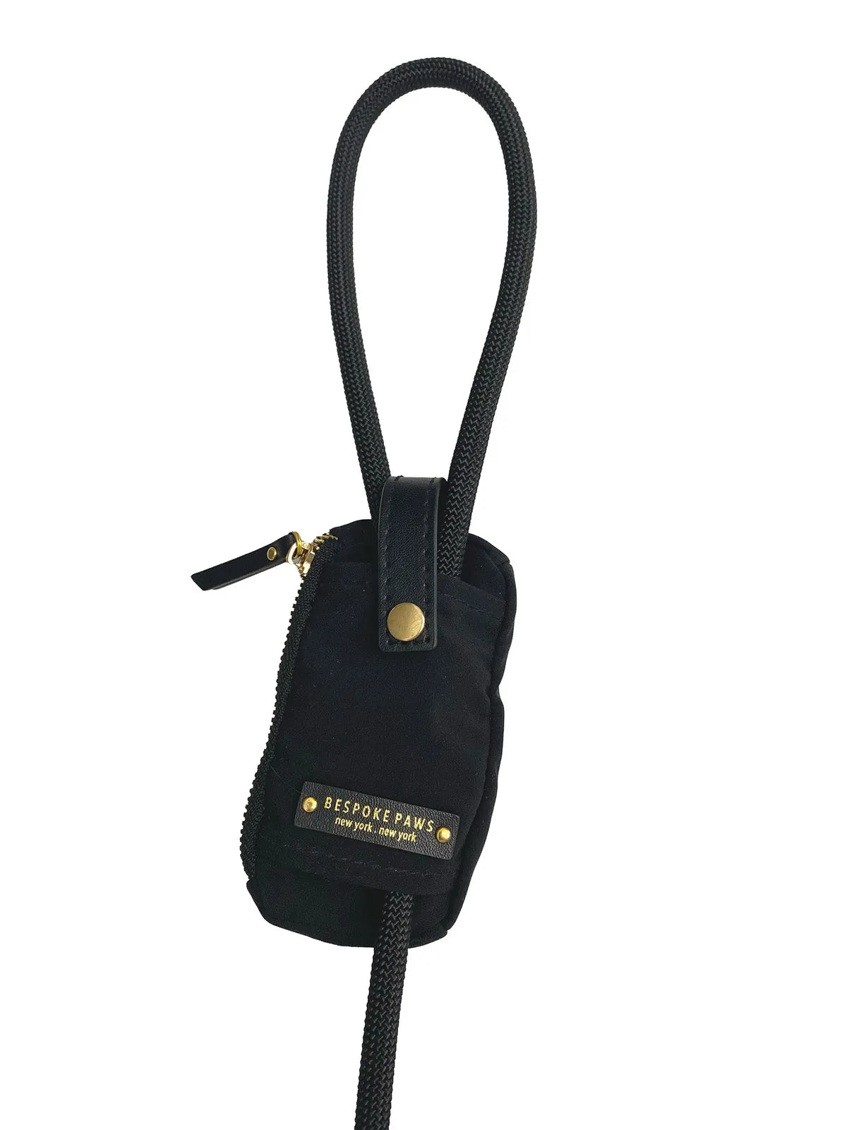 Sleek black waste bag dispenser with vegan leather accents, featuring a dangle-free design and gold logo detail.