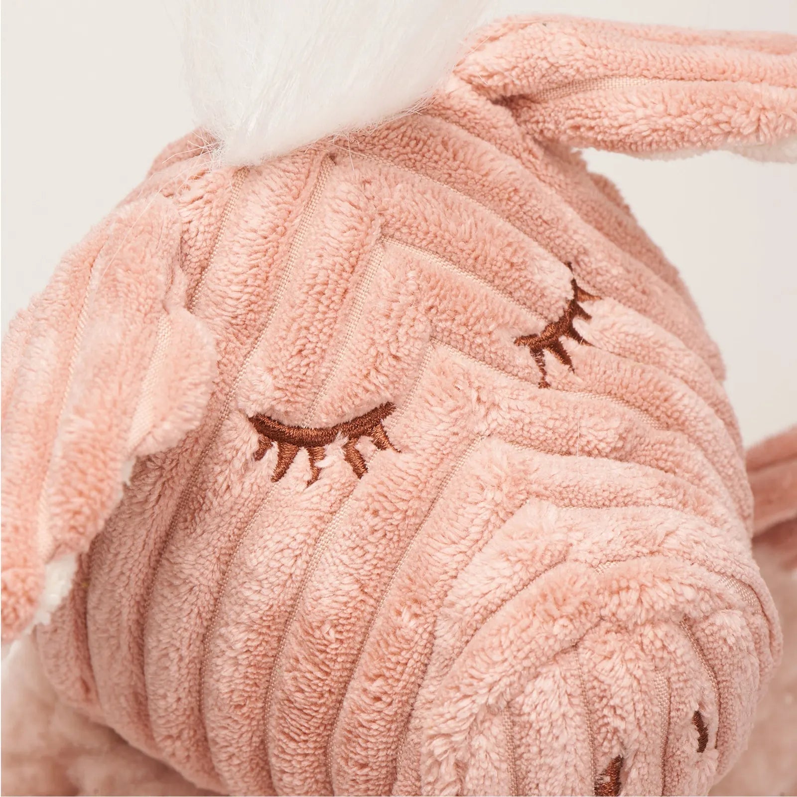 Soft pink plush Penelope Pig toy featuring stitched eyes and textured huggable fabric, perfect for dogs to snuggle and play.