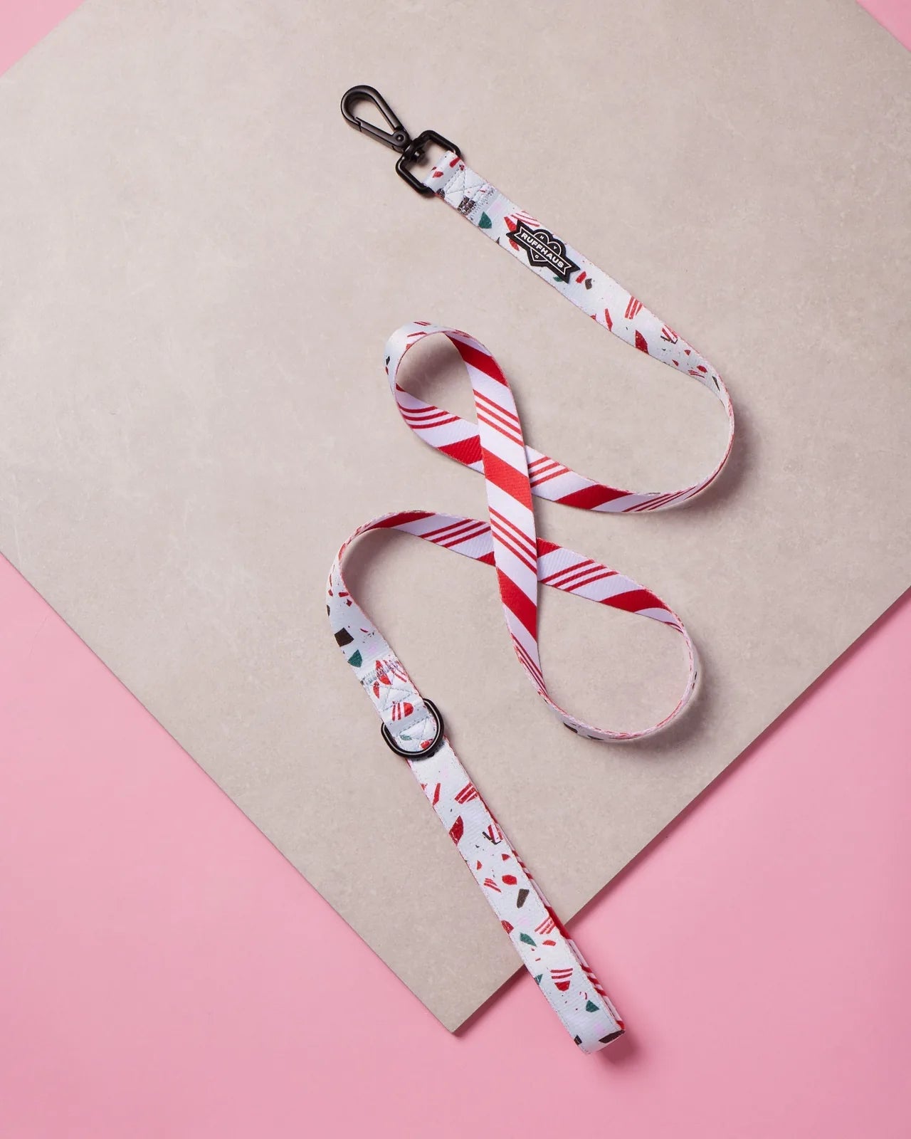 Peppermint Bark dog leash with red and white stripes, featuring a swivel snap clasp and neoprene handle, styled on a pink...