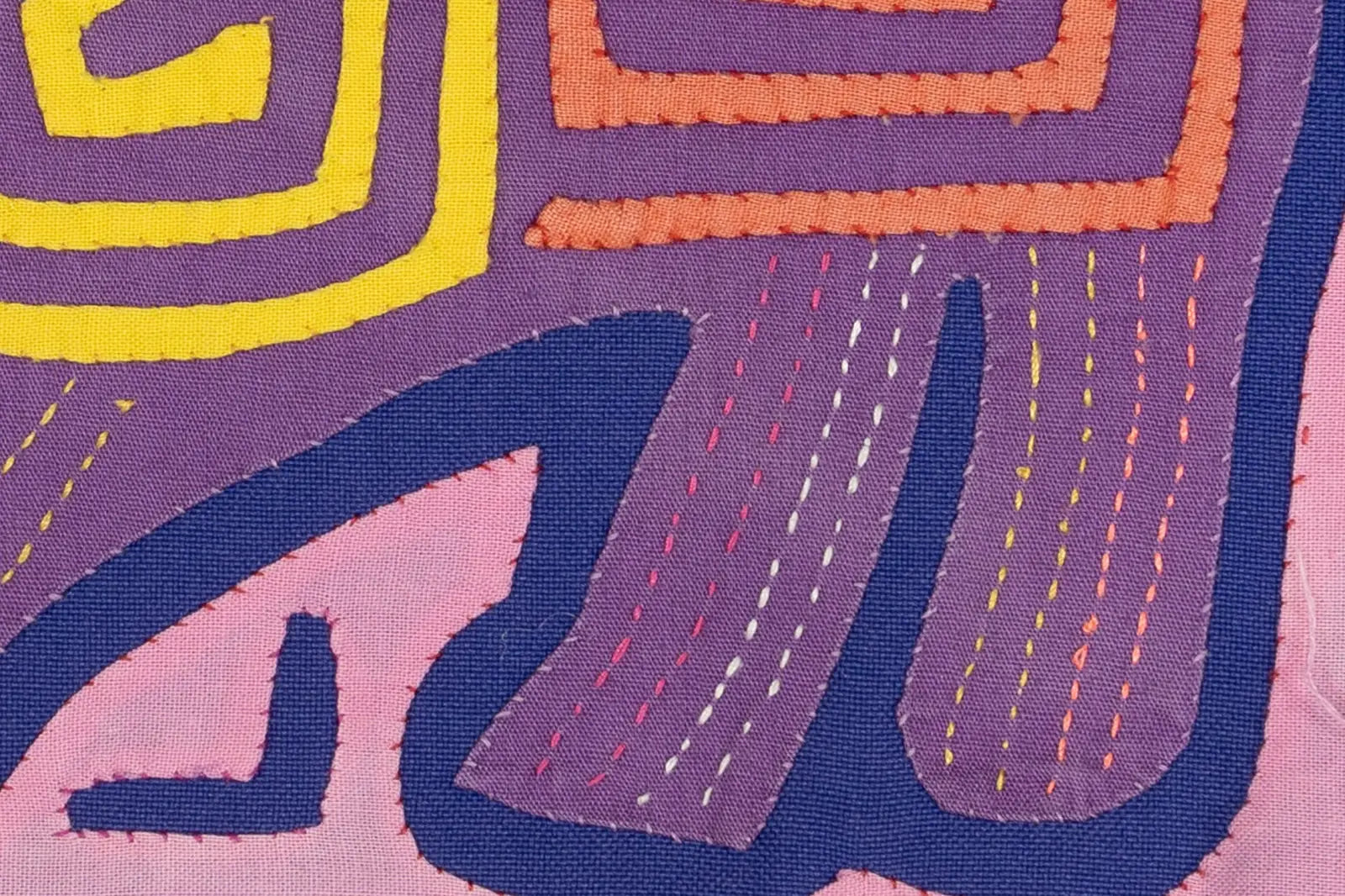Colorful pink and purple fabric featuring intricate geometric patterns and hand-stitched details, showcasing a unique Mola...