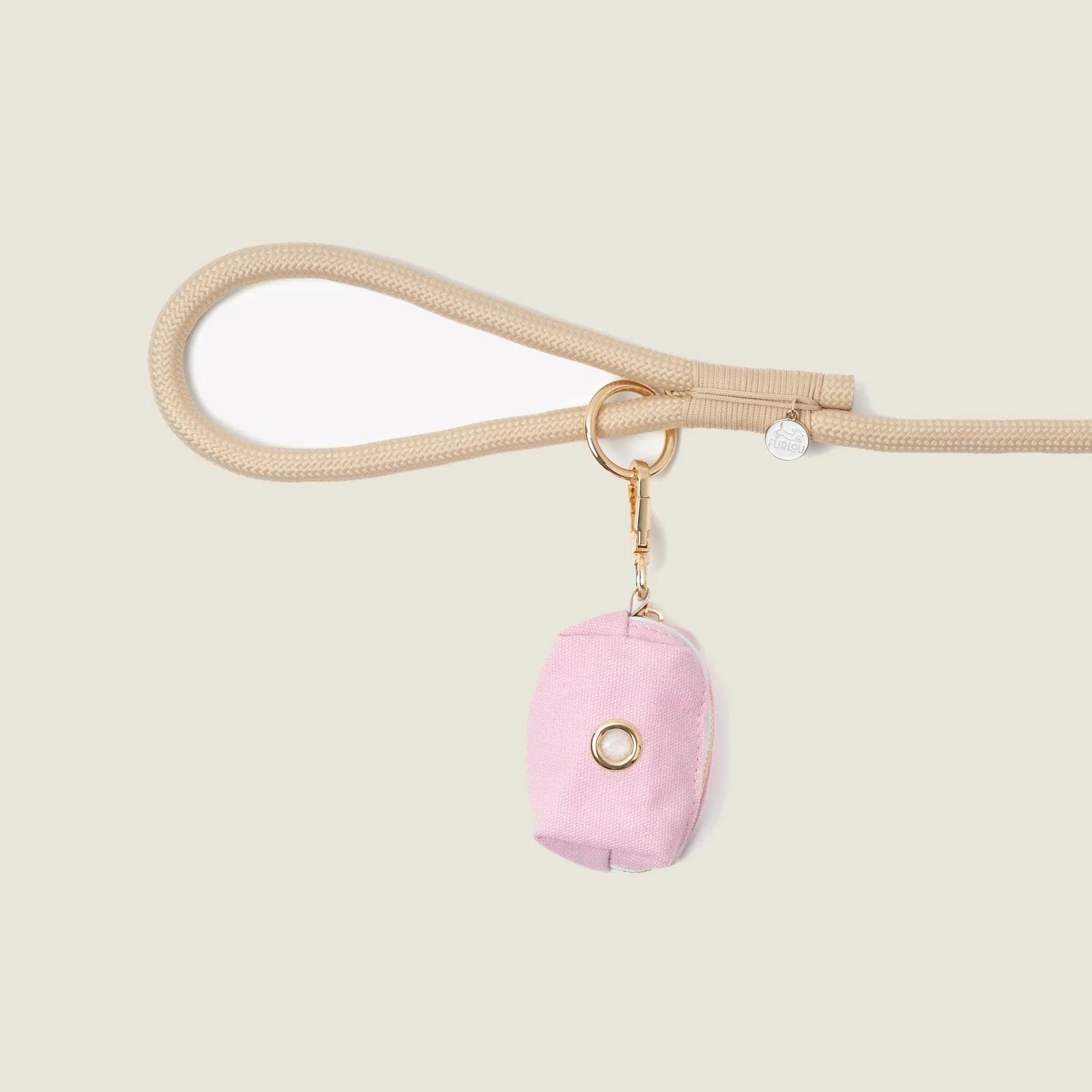Compact pink poop bag holder by FURLOU, attached to a beige leash with a gold clip for easy access during walks.