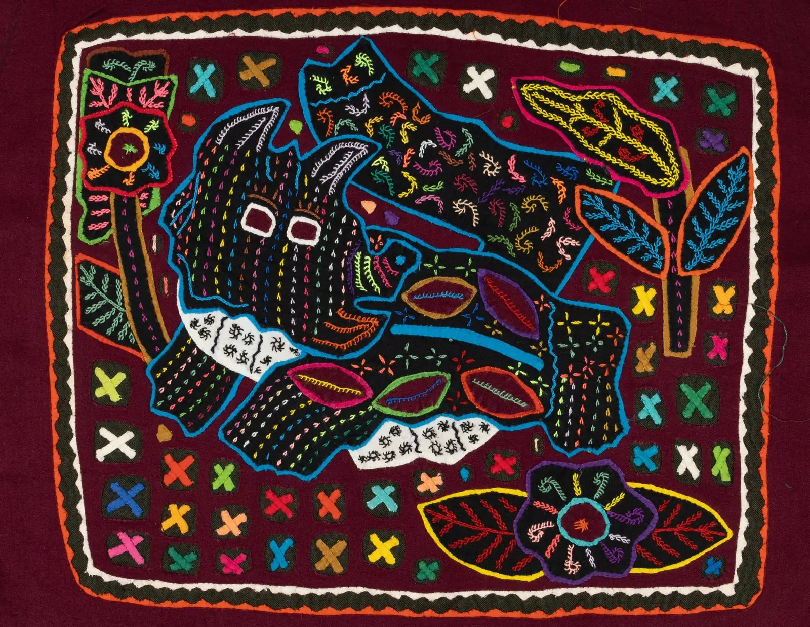 Hand-stitched terrier puppy design in vibrant colors, surrounded by floral motifs on a rich maroon textile.
