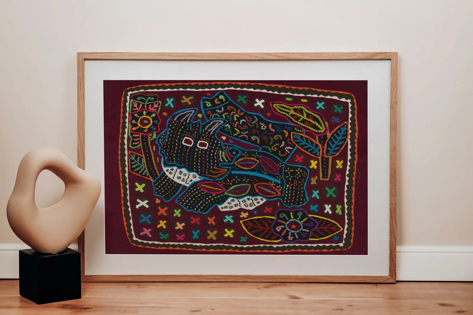 Hand-stitched terrier puppy Mola in vibrant colors with floral patterns, framed as decorative tapestry art.
