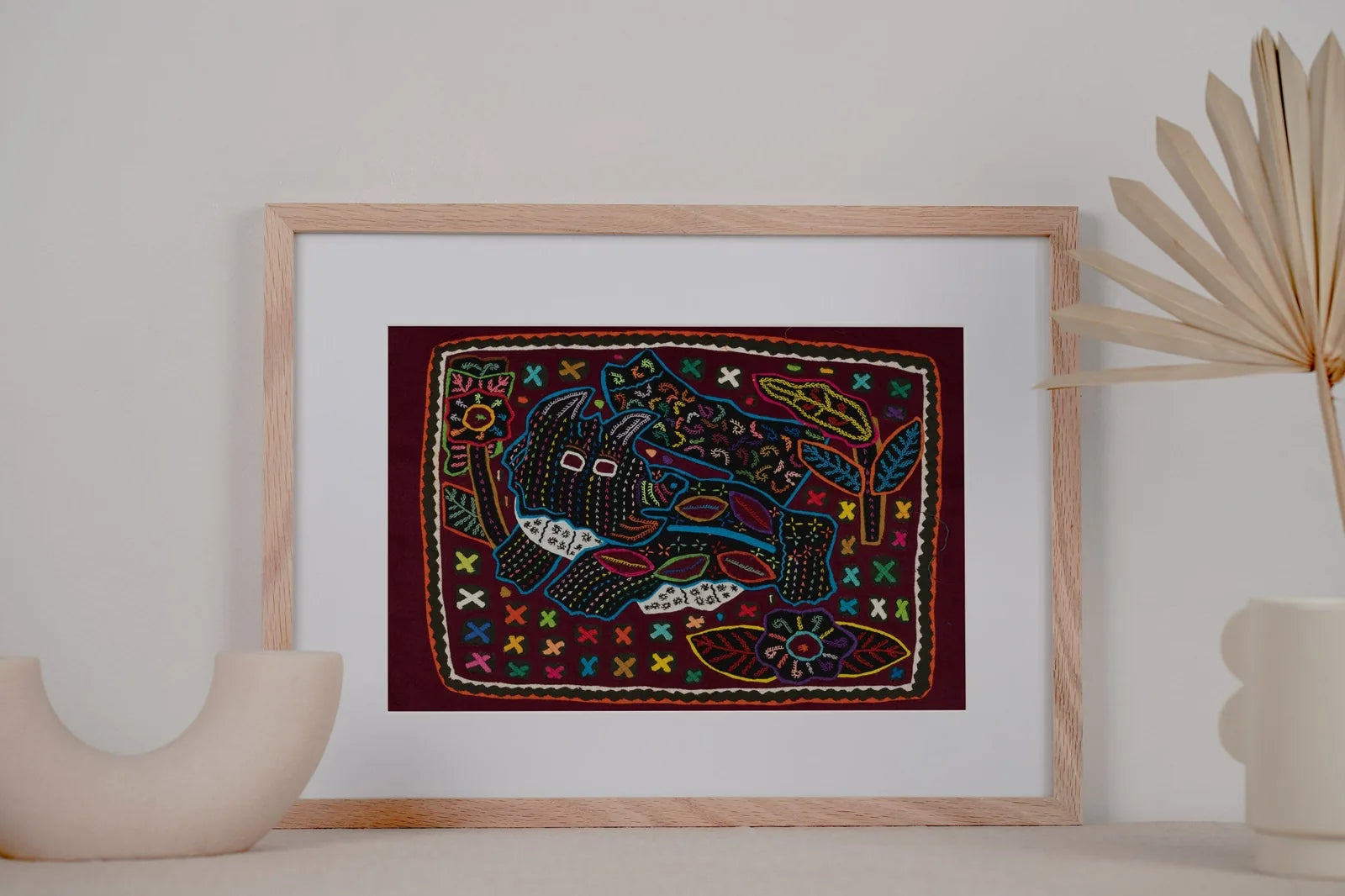 Hand-stitched Mola tapestry featuring a playful terrier puppy design in vibrant colors on a dark background.