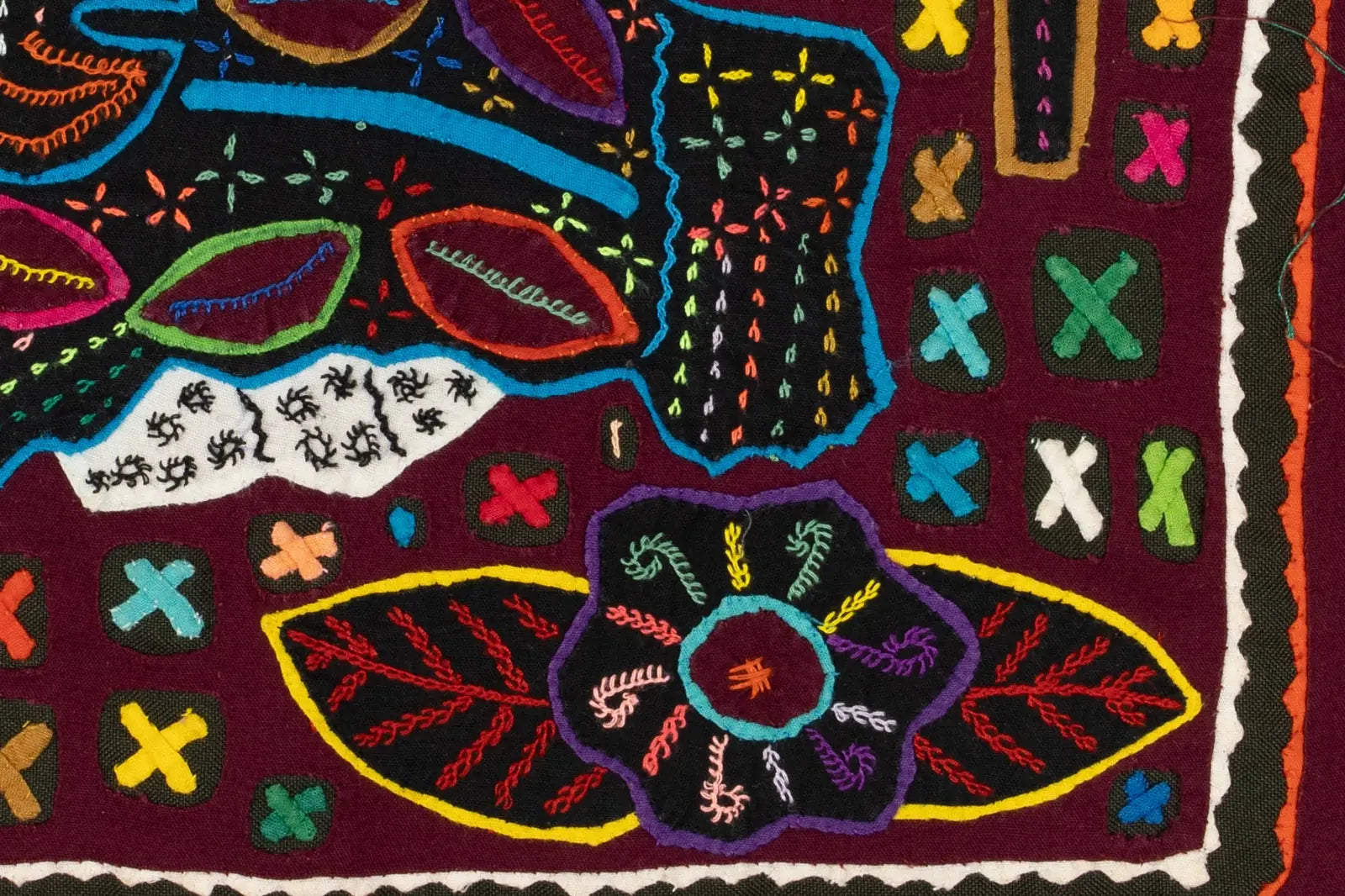 Colorful hand-stitched Mola featuring intricate floral and geometric designs on a dark background, showcasing traditional...