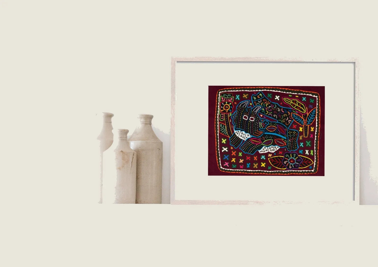 Hand-stitched textile art featuring a playful terrier puppy on a vibrant burgundy background with colorful geometric designs.