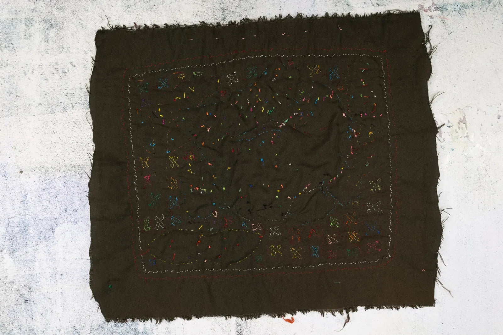 Hand-stitched dark fabric featuring colorful geometric embroidery, showcasing unique Panama Mola textile art.